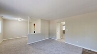 Located at 5303 Rue De Ville in Indianapolis, Indiana, this single-floor residence offers a practical and comfortable layout with two bedrooms and two bathrooms. The living room is bright and welcoming, featuring plush carpeting and a sliding glass door that fills the space with natural light and provides a view of the surrounding greenery outdoors. The kitchen is equipped with warm wood-toned cabinetry, white appliances including a full-size refrigerator and dishwasher, and light wood-style flooring, offering a functional cooking space. The spacious primary bedroom features neutral carpet, soft neutral-toned walls, and generous built-in closet storage with louvered bifold doors and shelving, along with a window that lets in natural light. The second bedroom is also carpeted and well-proportioned, with access to adjacent hallway areas. Two full bathrooms serve the home: one features a tub-shower combination with white tile surround and wood-look flooring, while the second offers a white vanity, a large mirror with overhead lighting, and matching wood-look flooring. Clean white trim and a consistent neutral color palette throughout the home create a cohesive and move-in-ready atmosphere.