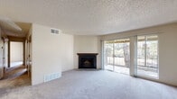 This single-floor residence offers 2 bedrooms and 4 bathrooms in a well-organized layout. The living room serves as the heart of the home, featuring plush wall-to-wall carpeting, a textured ceiling, and a corner wood-burning fireplace with a dark wood mantel. Sliding glass doors flood the space with natural light and open directly onto a private balcony overlooking mature trees, creating a seamless indoor-outdoor connection.

The kitchen is functionally designed with dark wood cabinetry, light-toned countertops, a skylight-style overhead fixture, and white appliances including a dishwasher, range, and oven. Durable tile flooring completes the practical aesthetic.

Both bedrooms are carpeted and finished with neutral tones and textured ceilings. The primary bedroom is generously sized, featuring sliding glass door access to an outdoor balcony with open views. Each bedroom benefits from dedicated closet space — one with a walk-in closet equipped with dual hanging rods and shelving, and another with a standard reach-in closet. The four bathrooms are cleanly appointed with tiled flooring and full tub-shower combinations, ensuring ample accommodations for residents and guests alike.