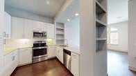 This contemporary 640 square foot apartment at The Canal offers a harmonious blend of style and functionality. The open-concept living area is characterized by high ceilings and large, arched windows that flood the space with natural light. Rich hardwood flooring extends throughout the main living areas, creating a warm and inviting atmosphere.

The kitchen is a chef's delight, featuring sleek white cabinetry, stainless steel appliances, and a stylish backsplash. A generous island with a marble countertop provides additional workspace and casual dining options. The living room seamlessly connects to the kitchen, ideal for entertaining.

The spacious 140 square foot bedroom boasts plush carpeting and large windows, offering a cozy retreat. The bathroom impresses with a wide vanity, ample storage, and a large mirror. A walk-in closet provides generous storage space.

Additional features include a modern ceiling fan in the living area and recessed lighting throughout. The apartment's thoughtful design maximizes space efficiency while maintaining an open, airy feel. Located in unit 06-0206, this one-bedroom haven offers a perfect balance of comfort and contemporary living.