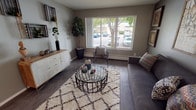 This thoughtfully renovated two-bedroom, one-bathroom unit offers a well-designed single-floor layout with contemporary finishes throughout. The living room is a welcoming space anchored by dark hardwood-style flooring, neutral toned walls, and a large picture window that fills the room with natural light and offers views of the surrounding greenery. The galley-style kitchen is efficiently designed with grey wood-tone cabinetry, quartz countertops, a tile backsplash, stainless steel appliances, and ample upper and lower cabinet storage. Adjacent to the kitchen, the dining area features warm wood-look flooring, a bold terracotta accent wall, and a ceiling fan overhead, creating a cozy and vibrant atmosphere. The primary bedroom is a comfortable retreat with carpeted flooring and access to a closet, while the second bedroom offers flexibility as a guest room or home office, complete with a window and natural light. The shared bathroom has been updated with a quartz-topped vanity, wood-tone cabinetry, a large mirror, and a shower-tub combination. Clean lines, updated fixtures, and cohesive design elements make this a move-in-ready home with modern appeal.