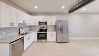 Located at 343 W Fourth St in Williamsport, PA, this thoughtfully designed one-bedroom, one-bathroom unit offers a clean, modern aesthetic across a single floor. The open-concept living and dining area is bright and airy, featuring light hardwood-style flooring, recessed lighting, a ceiling fan, and multiple windows that bring in natural light and views of the surrounding neighborhood.

The kitchen is a standout feature, outfitted with crisp white shaker cabinets accented by matte black hardware, granite countertops, and a full suite of stainless steel appliances including a refrigerator with ice and water dispenser, electric range, built-in microwave, and dishwasher. An exposed ductwork element adds an industrial touch to the otherwise contemporary design.

The generously sized primary bedroom offers ample space, continuing the light flooring and neutral palette, with a ceiling fan, recessed lighting, and windows providing natural light. The bathroom features granite countertops, an undermount sink with matte black fixtures, a large mirror, and coordinating light tile flooring. Additional conveniences include a dedicated laundry area, a utility room, and a closet for storage. The unit's fresh, modern finishes and functional layout make it a well-appointed space.