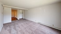 Located at 7342 W Marine Dr in Milwaukee, Wisconsin, this single-floor unit offers a straightforward, functional layout designed for comfortable everyday living. The living area is finished with plush carpeting and features a ceiling fan with integrated lighting, providing both air circulation and ambient illumination. A pass-through counter connects the living space to the kitchen, creating an open feel between the two areas. The kitchen is equipped with wood-toned cabinetry, dark laminate countertops, a white electric range, and an overhead ventilation hood, offering practical workspace and ample storage.

The bedrooms are carpeted and generously proportioned, each featuring built-in closets with bifold doors that provide organized storage. Baseboard heating units line the walls, ensuring consistent warmth throughout the cooler Milwaukee seasons. The bathroom includes wood-look vinyl flooring, a dark granite-style vanity countertop, a full tub-shower combination with tiled surround, and chrome grab bars, adding both style and accessibility. Neutral white walls throughout the unit create a clean, versatile backdrop. The overall layout, visible in the floor plan, reflects a compact yet efficiently organized design suited for single-floor living.