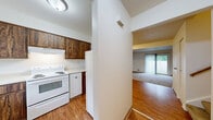 Located at 36 Charwood Cir in Rochester, NY, this multi-floor home offers a practical and well-organized layout spread across three levels. The main living area features a carpeted living room bathed in natural light, with a sliding glass door that opens to a fenced backyard, creating a seamless indoor-outdoor connection. The kitchen is equipped with dark wood cabinetry, white appliances including a coil-top range, a built-in range hood, and a single-basin sink beneath a window that brings in natural light. Laminate wood flooring grounds the space with a warm, durable finish. A dedicated laundry area with hardwood-style flooring and utility hookups adds everyday convenience. Both bedrooms are carpeted and bright, featuring neutral walls and windows for natural light. The primary bedroom stands out with two sets of bi-fold closet doors, offering generous storage capacity. The two bathrooms are clean and functional, featuring tile surround, a vanity with ample counter space, a large mirror, and a tub-shower combination. The lower level provides an unfinished utility space with painted concrete floors and exposed overhead systems, offering significant storage or future finishing potential. Staircases connect all three levels efficiently throughout the home.