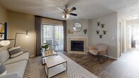 This single-story residence offers a thoughtfully designed layout across a comfortable footprint, combining functional living spaces with warm, neutral aesthetics throughout. The living room serves as the heart of the home, anchored by a tile-surround fireplace and sliding glass doors that open to a private outdoor patio, filling the space with natural light. A ceiling fan overhead adds to the room's practicality and comfort.

The dining area connects seamlessly to the kitchen via a pass-through window, creating an open, communicative flow between spaces. Wood-look flooring runs through the main living areas, adding a cohesive, contemporary feel.

Both bedrooms are carpeted and feature ceiling fans and windows that invite natural light. The primary bedroom includes a dedicated walk-in closet with wire shelving, offering substantial storage. Each bedroom is served by its own full bathroom; one bathroom features a tub-shower combination with a large vanity mirror, while the second includes a walk-in shower. Both bathrooms feature granite-style countertops and white cabinetry.

Additional highlights include two closets for extra storage and a dedicated in-unit laundry area, rounding out this well-equipped residence.
