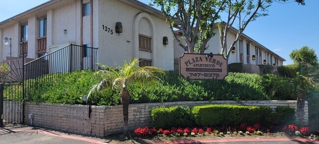 Gated front enterance with lush gardens at Plaza Verde Apartments in  Escondido, California. - Plaza Verde