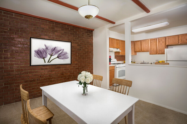 Separate dining area with exposed brick at Whitehall Square Apartments - Whitehall Square Apartments