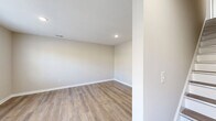 Located at 9 Pruchnic Ln in Verona, Virginia, this two-story home offers a thoughtfully designed layout spread across two floors. The main level hosts the living room, kitchen, laundry, and a full bathroom, while the upper level accommodates both bedrooms and an additional bathroom.

The kitchen is a standout feature, outfitted with crisp white shaker cabinetry, granite countertops, and a full suite of black Whirlpool appliances including a side-by-side refrigerator, electric range, over-the-range microwave, and dishwasher. Natural light filters in through multiple windows, complementing the light-toned luxury vinyl plank flooring found throughout the main living areas.

The bedrooms are carpeted for comfort, with the primary bedroom offering generous proportions and a large window that frames outdoor views of the surrounding Virginia landscape. The second bedroom is equally well-lit with natural light. Both bathrooms are finished with white vanities featuring clean countertops, with the upper bath showcasing a stylish gray vanity and modern light fixture. Four closets throughout the home provide ample storage. The overall aesthetic is fresh and neutral, with warm beige tones, recessed lighting, and clean white trim creating a bright, move-in-ready atmosphere.