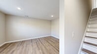 Located at 9 Pruchnic Ln in Verona, Virginia, this two-story home offers a thoughtfully designed layout spread across two floors. The main level hosts the living room, kitchen, laundry, and a full bathroom, while the upper level accommodates both bedrooms and an additional bathroom.

The kitchen is a standout feature, outfitted with crisp white shaker cabinetry, granite countertops, and a full suite of black Whirlpool appliances including a side-by-side refrigerator, electric range, over-the-range microwave, and dishwasher. Natural light filters in through multiple windows, complementing the light-toned luxury vinyl plank flooring found throughout the main living areas.

The bedrooms are carpeted for comfort, with the primary bedroom offering generous proportions and a large window that frames outdoor views of the surrounding Virginia landscape. The second bedroom is equally well-lit with natural light. Both bathrooms are finished with white vanities featuring clean countertops, with the upper bath showcasing a stylish gray vanity and modern light fixture. Four closets throughout the home provide ample storage. The overall aesthetic is fresh and neutral, with warm beige tones, recessed lighting, and clean white trim creating a bright, move-in-ready atmosphere.
