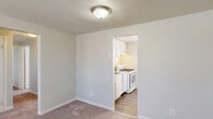 Located at 3 Marhoefer Drive in Pleasant Hills, Pennsylvania, this single-floor residence offers a functional and straightforward layout across four bedrooms, one full bathroom, a kitchen, and a connecting hallway. The floor plan makes efficient use of its space, with each room thoughtfully arranged for accessibility and flow.

The bedrooms feature soft wall-to-wall carpeting and neutral, light-toned walls that create a clean and understated atmosphere. Several bedrooms are equipped with ceiling fans and windows fitted with horizontal blinds, allowing for natural light and ventilation. Baseboard heating units are present throughout, ensuring year-round comfort.

The compact kitchen is outfitted with white cabinetry, a gas range, and a sink, all set against light wood-look flooring. Its open entryway from the adjacent carpeted area allows for easy connectivity between spaces.

The hallway area features light wood-look flooring and a window that brings in natural light, along with a door providing exterior access.

The full bathroom is finished with classic white subway tile surrounding a tub-shower combination, complemented by chrome fixtures and a window for natural ventilation, lending a bright and clean aesthetic.

The primary bedroom is notably spacious, offering ample room for comfortable furnishing. Throughout the residence, the consistent neutral color palette and clean finishes provide a move-in-ready environment.