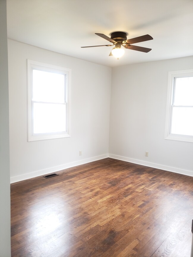 Nice size bedroom with ceiling fans, hardwood floors and windows for natural lighting. - 2713 Jenkins St