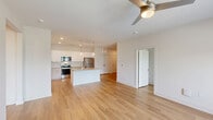 Located at 2410 Smith Gln Rd in Charlotte, NC, this well-designed single-story home offers three bedrooms and three bathrooms within a thoughtfully laid-out floor plan. Light-toned hardwood-style flooring runs throughout the entire home, creating a cohesive and modern aesthetic.

The kitchen is a standout feature, boasting white upper cabinetry, warm-toned lower cabinets, a herringbone tile backsplash, granite countertops, stainless steel appliances, and a central island with a built-in sink and pendant lighting overhead. The open layout connects the kitchen seamlessly to the living area, which is brightened by natural light from large windows fitted with white blinds and a ceiling fan.

Each bedroom is bright and airy, featuring ceiling fans, windows with outdoor views of the surrounding neighborhood, and generous closet space. The closets are outfitted with wire shelving systems for practical organization.

All three bathrooms maintain a clean, contemporary design, each featuring granite-topped vanities, tub-shower combinations, and warm hardwood-style flooring. A connecting hallway ties the layout together efficiently.

The overall ambiance of the home is clean, bright, and move-in ready, reflecting modern finishes and a neutral palette throughout.
