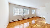 Located at 220 Sullivan Way in Ewing, NJ, this one-bedroom, one-bathroom unit offers a practical and well-appointed single-floor layout. Warm hardwood flooring runs throughout the main living areas and bedroom, lending a consistent and inviting character to the space.

The living room is notably bright, benefiting from a bank of large windows that allow generous natural light to fill the room. A wall-mounted air conditioning unit and baseboard heating provide year-round climate control. The open layout connects seamlessly to the galley-style kitchen, which features rich, dark wood cabinetry, dark countertops, and stainless steel appliances including a refrigerator, range, and built-in microwave. Pendant and flush-mount lighting illuminate the kitchen effectively.

The bedroom is a comfortable size, offering a double-door closet for storage, hardwood flooring, a window for natural light, and baseboard heating. The bathroom is finished with marble-style tile flooring, a white vanity with storage, a full soaking tub with shower, and a window that provides ventilation and natural light. Clean white walls throughout the unit contribute to a bright, neutral aesthetic that is easy to personalize.