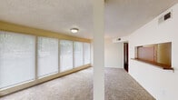 This single-floor, 2-bedroom, 1-bathroom unit in Memphis, Tennessee offers a functional and well-organized layout. The living area is bright and open, featuring wall-to-wall carpeting, a textured ceiling, and a wide bank of windows fitted with horizontal blinds that allow ample natural light to fill the space. A structural column adds architectural definition between the living and dining areas, while a chandelier overhead accents the dining space.

The kitchen is accessible via a pass-through window with a countertop bar, offering a connected feel to the main living area. Inside, the kitchen features warm wood cabinetry, granite-style countertops, hardwood flooring, and a dishwasher, providing practical functionality in a compact footprint.

Both bedrooms are carpeted and include ceiling fans with light fixtures and windows that bring in natural light. The primary bedroom is a comfortable size and connects to a walk-in closet equipped with shelving and a built-in surface for added storage versatility. The second bedroom also offers closet access.

The bathroom includes a full tub-shower combination, a single-sink vanity with wood cabinetry, and tile flooring. Hallways connect the rooms efficiently, completing the home's straightforward and practical floor plan.
