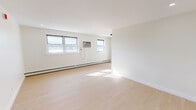 Located at 921 Tyson Ave in Philadelphia's 19111 zip code, this single-floor, one-bedroom, one-bathroom unit offers a thoughtfully laid-out living space with a clean, modern aesthetic. Light-toned hardwood flooring runs throughout, lending a bright and cohesive feel to every room.

The spacious living room is bathed in natural light from multiple windows and features baseboard heating along the exterior wall, complemented by a wall-mounted air conditioning unit for year-round comfort. Recessed lighting adds to the well-lit atmosphere.

The bedroom is a comfortable, well-proportioned room with its own window for natural light, a baseboard heater, and a built-in double closet with bi-fold doors — providing ample storage. A second closet is also available within the unit, offering additional organizational space.

The bathroom is finished with large-format, light gray tile surrounding a full soaking tub, accented by sleek matte black fixtures that add a contemporary touch. The kitchen and hallway complete the floor plan, connecting the spaces efficiently.

Throughout the unit, crisp white walls and clean trim work reinforce a modern, move-in-ready presentation. The overall ambiance is bright, minimalist, and functional — well-suited for those seeking a tidy, low-maintenance living space in Philadelphia.