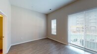 Located at 110 N Chestnut St in Olathe, Kansas, this single-floor unit offers a clean, modern aesthetic with a thoughtfully designed layout. The living area is bright and open, featuring warm-toned luxury vinyl plank flooring, neutral walls, and large windows fitted with horizontal blinds that allow natural light to fill the space. A sliding glass door provides outdoor access and adds to the airy feel of the room.

The kitchen is well-appointed and flows seamlessly from the living and dining area. It features a full suite of stainless steel appliances, including a refrigerator, range, over-the-range microwave, and dishwasher. White shaker-style upper cabinets are paired with gray lower cabinets and black hardware, complemented by white quartz countertops and a classic white subway tile backsplash. Light LVP flooring continues throughout this area, reinforcing the home's cohesive design.

The bathroom is efficiently laid out with a tiled soaking tub and shower combination, a gray vanity with ample drawer storage, white countertops, and matching LVP flooring. A doorway from the bathroom leads directly into a dedicated walk-in closet, offering generous storage. The consistent use of neutral tones and modern finishes throughout the space creates a clean, move-in-ready environment.