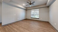 Located at 2130 Medical Center Pkwy in Murfreesboro, TN, this 2-bedroom, 1-bathroom residence offers a thoughtfully designed single-level layout with modern finishes throughout. The open-concept kitchen and living area serves as the heart of the home, featuring wood-look plank flooring, white shaker-style cabinetry, granite countertops, stainless steel appliances, and a peninsula with seating — ideal for both cooking and casual dining. Track lighting overhead adds a clean, functional aesthetic to the space. The primary bedroom is generously sized, with wood-look flooring, a ceiling fan, recessed lighting, and a window that brings in natural light. A dedicated walk-in closet with built-in wire shelving and carpeted flooring provides ample storage. The second bedroom also features carpet, a ceiling fan, and a window overlooking the greenery outside. The full bathroom is well-finished with marble-style tile flooring, a tub-shower combination with tile surround, a white vanity with granite countertops, and a large mirror. A private balcony offers serene views of the landscaped courtyard and the brick exterior of the building, completing this comfortable and stylish residence.