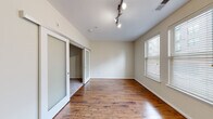 Located at 1901 S Charles St in Baltimore's South Baltimore neighborhood, this one-bedroom, one-bathroom unit offers a thoughtfully designed layout across a single floor. The living area is highlighted by warm hardwood flooring, neutral cream-toned walls, and stylish track lighting overhead. Natural light flows in through multiple windows fitted with horizontal blinds, creating a bright and inviting atmosphere. A frosted glass sliding door connects the living space to the bedroom, adding a modern architectural touch while maintaining an open feel.

The bedroom continues the hardwood flooring and benefits from a pair of large windows that invite ample natural light. A dedicated closet with carpeted flooring provides practical storage.

The galley-style kitchen is well-appointed with rich, dark espresso cabinetry featuring a decorative wine rack, granite countertops, a stainless steel sink, and a full suite of black appliances. Light tile flooring runs through the kitchen and into the hallway, which leads to the entrance.

The bathroom is finished with the same dark cabinetry and granite vanity countertop, complemented by light tile floors, a full tub-shower combo with white tile surround, and brushed nickel fixtures throughout. This unit offers a clean, modern aesthetic suited for comfortable everyday living.