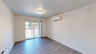 Located at 5102 W State St in Boise, Idaho, this well-designed one-bedroom, one-bathroom unit offers a clean, modern aesthetic across a single floor. The open living room is finished with durable wood-look flooring and neutral white walls, creating a bright and welcoming atmosphere. A wall-mounted mini-split HVAC unit ensures year-round climate control, while sliding glass doors lead to a private balcony, filling the room with natural light and offering views of the surrounding neighborhood.

The kitchen is thoughtfully appointed with crisp white cabinetry, white countertops, and a full suite of stainless steel appliances, including a refrigerator, electric range, and built-in microwave. A single-basin stainless sink and pendant lighting add practical, modern touches to the space.

The bedroom features plush carpeting, a window with blinds for natural light and privacy, and its own wall-mounted mini-split unit for personalized comfort. The bathroom maintains the home's clean design language with white cabinetry, a white countertop vanity, and wood-look flooring. Throughout the unit, the consistent use of light tones and modern finishes creates a cohesive, move-in-ready living environment.