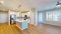 Located on International Drive in Orlando, Florida, this well-appointed 2-bedroom, 3-bathroom residence offers a thoughtfully designed single-floor layout. The open-concept kitchen and living area serves as the heart of the home, featuring warm wood-look flooring throughout. The kitchen is outfitted with crisp white cabinetry, glass-front upper cabinets, a grey subway tile backsplash, a large center island with a white countertop and undermount sink, pendant lighting, and a full suite of stainless steel appliances. The living area is bright and airy, with multiple windows dressed in horizontal blinds that allow ample natural light to fill the space.

The two bedrooms are carpeted for comfort, each with a ceiling fan and windows offering outdoor views. The generously sized primary bedroom includes access to a walk-in closet with wire shelving and built-in organization. The three bathrooms are finished with wood-look tile flooring, white vanities with clean countertops, and framed mirrors with modern brushed-gold hardware accents. Additional storage is provided by two closets throughout the unit. The overall aesthetic is clean and contemporary, with neutral tones, recessed lighting, and consistent finishes that create a cohesive, move-in-ready living environment.