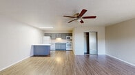 Located at 1210 Country Club Rd in Sunland Park, NM, this single-floor unit offers a practical and well-designed layout comprising a living room, kitchen, and bathroom. The interior is finished with durable wood-look flooring throughout, lending a clean and cohesive aesthetic to the entire space.

The open living area is bright and functional, featuring neutral-toned walls, a textured ceiling, and a ceiling fan with a built-in light fixture. A wall-mounted HVAC unit provides climate control, and a window allows natural light to fill the room, creating a welcoming atmosphere.

The kitchen is a standout feature, equipped with grey cabinetry, marble-look countertops, and a peninsula island that serves as both a prep and dining surface. White appliances — including a refrigerator, electric range, dishwasher, and over-the-range microwave — are fully integrated. Under-cabinet lighting illuminates the workspace, and a stainless steel sink adds a modern touch. An adjacent closet area provides additional storage.

The bathroom is clean and simply appointed, featuring a full-size tub and shower combo with chrome fixtures, complemented by neutral wall tones. The overall design of this unit prioritizes functionality and ease of maintenance, making it a practical living space in the Sunland Park community.