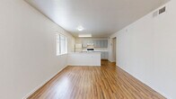 Located at 234 W Southern Ave in Phoenix, AZ, this single-story, one-bedroom, one-bathroom unit offers a practical and well-organized layout across a compact but efficiently utilized floor plan. The open-concept living, dining, and kitchen area forms the heart of the unit, providing a seamlessly connected space ideal for everyday living. Warm wood-style flooring runs consistently throughout, lending a cohesive and inviting feel to every room.

The kitchen is equipped with gray cabinetry extending both above and below the countertops, offering ample storage, and features white appliances including a refrigerator and an electric range with a ventilation hood. A peninsula-style counter creates a natural division between the kitchen and the living/dining area. Large vertical-blind windows allow natural light to fill the main living space.

The bedroom is a well-proportioned room with its own vertical-blind window, wood-style flooring, and access to closet storage. The unit includes two closets in total, providing generous storage capacity. The bathroom features a full tub/shower combination with white tile surround and accessibility-friendly grab bars. A hallway connects the private areas of the unit to the main living space, maintaining a clear and functional flow throughout.