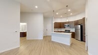 Located at 11110 Lantern Rd in Fishers, Indiana, this well-appointed 2-bedroom, 3-bathroom residence offers a thoughtfully designed single-floor layout with modern finishes throughout. The open-concept kitchen and living area serves as the heart of the home, anchored by a large center island with a white quartz countertop, stainless steel sink, and stylish pendant lighting. Rich dark-wood cabinetry lines the kitchen walls alongside stainless steel appliances, including a refrigerator, range, and microwave. Light wood-style flooring flows seamlessly through the main living areas, complemented by recessed lighting and neutral white walls that create a bright, airy ambiance. The living room benefits from ceiling fans and access to natural light through large windows and a glass door leading to the outdoors. The spacious primary bedroom features plush carpeting, a ceiling fan, and a generous walk-in closet with wire shelving for ample storage. The second bedroom also offers carpeted flooring and natural light from a bright window. Each bathroom is finished with dark wood vanities, white quartz countertops, and light wood-style tile flooring. With three well-appointed closets throughout, this residence provides excellent storage and a clean, contemporary aesthetic.