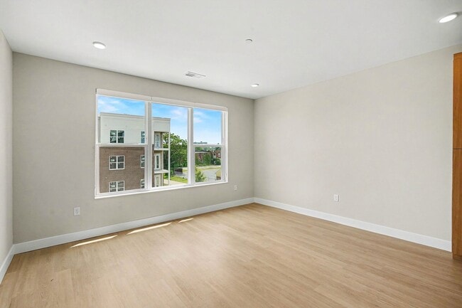 Embrace modern living at Trail House Apartments with this spacious, sunlit interior. Large windows invite natural light and offer a serene view. Ideal for customizing your personal space. Schedule your visit today to see it in person! - Trail House Apartments
