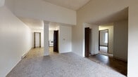 Located at 69 Jadwin Avenue in Richland, Washington, this single-floor unit offers a practical and comfortable layout designed for everyday living. The open living and dining areas are finished with plush carpeting and feature large windows that bring in natural light while offering views of the surrounding neighborhood. Baseboard heating is present throughout the carpeted rooms, ensuring warmth and comfort year-round.

The kitchen is well-appointed with dark wood cabinetry, a white appliance suite including an electric range, dishwasher, and refrigerator, and durable tile flooring. A ceiling fan adds airflow to the space. An adjacent pantry or storage closet provides additional organizational convenience.

The bedrooms are generously proportioned, each with soft carpeting, large windows, and baseboard heaters. Closet storage is available, with at least one room featuring a dedicated closet with a hanging rod and shelf.

The bathroom includes tile flooring, a vanity with under-sink cabinetry, and a large mirror. A dedicated laundry area houses a washer and dryer alongside a water heater, all set on tile flooring. Dark wood interior doors with brass hardware add a consistent design detail throughout the unit.