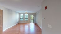 Located at 1331 Walnut St in Cincinnati's urban core, this single-floor residence offers a thoughtfully designed layout with a clean, modern aesthetic throughout. The living area is bright and open, featuring warm hardwood flooring, neutral gray walls, and a ceiling fan. Multiple windows invite abundant natural light and provide views of the surrounding greenery, while a glass door opens to an outdoor access point, enhancing the sense of connectivity to the outside.

The kitchen is well-equipped and functional, showcasing warm-toned wood cabinetry that extends to the ceiling for ample storage, dark countertops, a white tile backsplash, and a full suite of black appliances including a refrigerator, electric range with microwave, and dishwasher. Hardwood flooring continues seamlessly from the living area into the kitchen, creating a cohesive flow.

The bedroom features plush carpeting, soft gray walls, and a pair of windows with blinds that frame views of the neighboring streetscape, offering both natural light and privacy. The full bathroom is finished with tile flooring, a wood vanity with a granite-style countertop, a large mirror, and a tub-shower combination with white tile surround and grab bar.