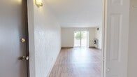 Located at 2 McCusker Drive in Braintree, MA, this single-floor, 3-bedroom, 2-bathroom home offers a well-organized layout with consistent light wood flooring throughout. The open living room is a standout feature, bathed in natural light from large sliding glass doors that lead directly to a private balcony with outdoor views. The bright, neutral color palette and textured accent walls lend a clean, welcoming ambiance to the space. The galley-style kitchen is efficiently designed with ample warm wood cabinetry, generous counter space, and full-size appliances including a refrigerator and range. A pass-through cutout connects the kitchen area to the main living space, enhancing the open feel. Three well-proportioned bedrooms feature the same wood flooring and crisp white walls, with the spacious primary bedroom offering notable square footage. Three closets provide ample storage throughout. The two bathrooms include vanities with wood cabinetry, tile flooring, and textured walls. Overall, the home presents a functional, light-filled layout suited for comfortable everyday living in a residential Braintree neighborhood.