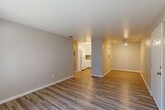 Located at 4146 Madison Ave in North Highlands, CA, this one-bedroom, one-bathroom unit offers a thoughtfully designed single-floor layout. The open-concept living and dining area is finished with durable wood-look vinyl flooring and neutral gray walls, creating a clean, modern aesthetic. A sliding glass door fills the living space with natural light and provides direct access to a private outdoor patio, offering pleasant outdoor views.

The kitchen is efficiently designed in a U-shaped configuration, featuring white cabinetry, granite-look countertops, a stainless steel sink, and white appliances including a refrigerator and electric range with overhead lighting. The space is both functional and bright.

The bedroom is a comfortable, well-proportioned room with plush carpeting, neutral tones, and a window that allows natural light and garden views. The full bathroom is clean and simply appointed, with wood-look flooring, a single vanity, and a shower-tub combo. A dedicated entryway with a paneled white door provides a welcoming transition into the home. Throughout, the unit maintains a consistent, neutral palette and practical finishes that make for an inviting and functional living space.
