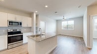 Located at 21932 Bellaire Blvd in Houston, TX, this single-story 2-bedroom, 2-bathroom home offers a thoughtfully designed layout with modern finishes throughout. The open-concept kitchen and living area serves as the heart of the home, anchored by a granite-topped island with an undermount sink, white shaker cabinetry, a subway tile backsplash, and stainless steel appliances including a French door refrigerator. Light wood-style flooring flows seamlessly through every room, complementing the neutral color palette. The living area benefits from natural light through a large window and is outfitted with a ceiling fan. The spacious primary bedroom features a ceiling fan, direct access to an en-suite bathroom, and an adjoining walk-in closet with wire shelving. The primary bathroom is finished with a granite-top vanity, a large mirror, and a soaking tub with marble-style tile surround. The second bedroom is equally bright, with a generous window offering outdoor views and its own ceiling fan. A second full bathroom and additional closet provide convenience for guests. An in-unit stacked washer and dryer area is tucked within the kitchen space, adding practical functionality to this clean, contemporary home.