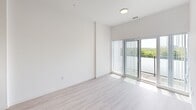 Located on the fifth floor at 375 South Street in London, Ontario, this thoughtfully designed two-bedroom unit offers a bright and contemporary living experience. The open-concept layout makes efficient use of the available space, connecting the main living area to a well-appointed kitchen with clean, modern cabinetry. Light wood-toned flooring runs throughout, complementing the crisp white walls and creating a consistent, airy aesthetic across every room.

The living area is bathed in natural light, thanks to a sliding glass door that opens onto a private balcony, offering pleasant treetop and cityscape views of the surrounding neighbourhood. Vertical blinds provide adjustable light control while maintaining the unit's clean, minimal design.

Both bedrooms are well-proportioned and finished with the same light flooring and white walls found throughout the unit. The primary bedroom features a large window that frames outdoor greenery and fills the room with natural light. The second bedroom includes a sliding-door closet with built-in shelving and hanging space, offering practical storage. A hallway connects the living areas and bedrooms, providing a logical and functional flow. Overall, this unit delivers a modern, move-in-ready space with a calm, understated ambiance ideal for comfortable urban living.