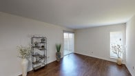 This single-story residence offers two bedrooms and two bathrooms within a thoughtfully arranged floor plan. The living area serves as the heart of the home, featuring rich wood-look flooring that extends underfoot and crisp white walls that create a clean, open feel. A sliding glass door with vertical blinds floods the space with natural light and provides direct access to an outdoor area, enhancing the sense of openness.

Adjacent to the living area, the dining space is defined by built-in counter detailing and overhead lighting, with continued wood-look flooring maintaining a cohesive aesthetic. The kitchen is efficiently designed with light wood cabinetry, white appliances including a range, over-the-range microwave, and refrigerator, along with light-toned countertops that offer functional workspace.

Both bedrooms are carpeted for comfort, each featuring a ceiling fan with light fixture and closet storage with built-in shelving and hanging rods. The rooms are well-proportioned with windows that invite natural light.

The two bathrooms are finished with light wood cabinetry, light countertops, large mirrors, and tub-shower combinations. Textured walls add a subtle design element throughout the bathrooms, completing this well-maintained and functional single-floor residence.