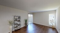 This single-story residence offers two bedrooms and two bathrooms within a thoughtfully arranged floor plan. The living area serves as the heart of the home, featuring rich wood-look flooring that extends underfoot and crisp white walls that create a clean, open feel. A sliding glass door with vertical blinds floods the space with natural light and provides direct access to an outdoor area, enhancing the sense of openness.

Adjacent to the living area, the dining space is defined by built-in counter detailing and overhead lighting, with continued wood-look flooring maintaining a cohesive aesthetic. The kitchen is efficiently designed with light wood cabinetry, white appliances including a range, over-the-range microwave, and refrigerator, along with light-toned countertops that offer functional workspace.

Both bedrooms are carpeted for comfort, each featuring a ceiling fan with light fixture and closet storage with built-in shelving and hanging rods. The rooms are well-proportioned with windows that invite natural light.

The two bathrooms are finished with light wood cabinetry, light countertops, large mirrors, and tub-shower combinations. Textured walls add a subtle design element throughout the bathrooms, completing this well-maintained and functional single-floor residence.
