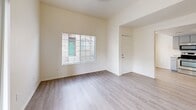 Located at 2651 W Broadway Blvd in Tucson, Arizona, this two-story home offers four bedrooms and four bathrooms across a thoughtfully laid-out floor plan. The main floor provides the larger share of the living space and includes a living room bathed in natural light through large vertical-blind-covered sliding doors, and a kitchen outfitted with stainless steel appliances — including a refrigerator, electric range, microwave, and dishwasher — complemented by gray cabinetry and light countertops. Light vinyl plank flooring flows consistently throughout the main level, lending a clean and cohesive aesthetic. A carpeted staircase connects to the upper floor, which houses additional bedrooms. The bedrooms feature plush carpet flooring and windows that bring in natural light. The primary bedroom offers a comfortable, well-proportioned retreat. Each of the four bathrooms is finished with a tub-shower combination, vanity with storage, and brushed nickel fixtures. Two hallways provide smooth circulation between spaces. The interior palette throughout is neutral and bright, with white and warm beige tones creating an open, airy feel well-suited to the sunny Tucson climate.