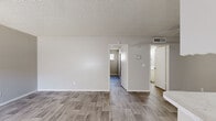 Located at 549 Sierra Vista Dr in Las Vegas, NV, this single-story, two-bedroom, one-bathroom residence offers a clean and functional layout across a compact, efficient footprint. Wood-look plank flooring runs consistently throughout the home, lending a cohesive and modern feel to every room.

The living room greets you at the entry, featuring a large window with vertical blinds that allow natural light to filter in, a textured ceiling, and neutral-toned walls that create a bright, open atmosphere. The galley-style kitchen is well-appointed with white cabinetry, a tile backsplash, light countertops, a gas range, and a full-size refrigerator. A peninsula counter with additional workspace adds functionality, while a ceiling fan overhead keeps the area comfortable.

The primary bedroom is generously sized and includes a sliding-door closet with dual hanging rods, providing ample storage. The second bedroom features its own window for natural light and shares the same wood-look flooring. The full bathroom offers a tub and shower combination accented by a distinctive colorful tile window feature, a vanity with a marble-look countertop, and wood-tone flooring. Textured ceilings are present throughout, adding a classic touch to this straightforward and well-maintained Las Vegas residence.