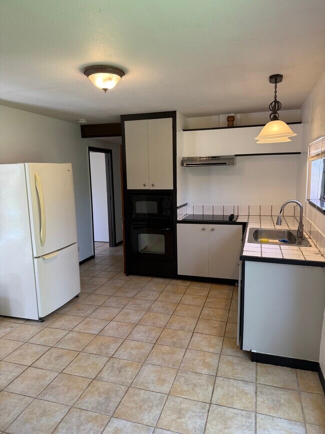 Vista de la cocina hacia el pasillo que conduce al baño y la entrada trasera. - 3333 Hamblen Ct