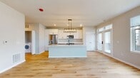 This contemporary 1-bedroom apartment in Elgin, IL offers 780 square feet of thoughtfully designed living space. The open floor plan maximizes the sense of spaciousness, with the kitchen, living, and dining areas seamlessly integrated. The kitchen is a standout feature, boasting white cabinetry, stainless steel appliances, and a large island with a waterfall countertop, perfect for casual dining or entertaining.

Natural light floods the space through large windows, enhancing the airy feel and providing views of the surrounding area. The flooring alternates between warm wood in the main living areas and plush carpet in the bedroom, adding texture and comfort. The bedroom, measuring 190 square feet, offers ample space and includes a closet with double doors.

The bathroom is modern and functional, with a spacious layout, sleek fixtures, and multiple grab bars for accessibility. In-unit laundry adds convenience to this well-appointed home. Throughout the apartment, neutral tones create a calm backdrop, allowing for personal touches in decor. This efficient single-floor layout combines style and practicality, ideal for contemporary urban living.