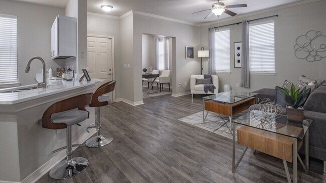 Moderna sala de estar de concepto abierto con barra de desayuno y suelo estilo madera. - Enders Place at Baldwin Park