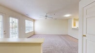 This 870 square foot apartment in Foley, Alabama, offers a well-designed single-floor living space. The open-concept layout seamlessly integrates the kitchen and living room, maximizing the use of space. The kitchen features light wood cabinetry, white appliances, and a practical breakfast bar, ideal for casual dining or additional workspace.

The primary bedroom, spanning 190 square feet, provides ample space and is illuminated by large windows, offering natural light and outdoor views. A ceiling fan enhances comfort and air circulation. The bedroom connects to a walk-in closet with built-in shelving and hanging rods, offering generous storage solutions.

Throughout the apartment, neutral-toned walls and carpeting create a bright, airy ambiance. The living area benefits from French doors leading to an outdoor space, further enhancing the sense of openness. Vinyl plank flooring in the kitchen adds a touch of durability and style.

The apartment's layout is efficient, with each area flowing naturally into the next, making the most of the available square footage. The overall design prioritizes functionality without sacrificing comfort, making it an ideal space for single occupants or couples seeking a low-maintenance, modern living environment.