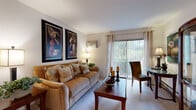 Located at 230 Stoneybrook Ln in Bloomingdale, IL, this single-floor, two-bedroom, two-bathroom residence offers a well-organized layout designed for comfortable everyday living. The living room serves as the heart of the home, featuring plush carpeting, large windows with vertical blinds, and a sliding glass door that fills the space with natural light and provides views of the greenery outside. The open sightlines connect the living area to the hallways and kitchen, creating a cohesive and functional flow throughout. The kitchen is equipped with warm honey-toned wood cabinetry, granite-style countertops, tile flooring, and white appliances including a range, refrigerator, and dishwasher — offering ample storage and workspace. The primary bedroom provides a comfortable retreat with carpeted floors, a sliding closet, and enough space to accommodate substantial furnishings. Both bathrooms are finished with tile flooring; one features a tub/shower combination with white tile surround, while the second includes a wood-framed vanity mirror and under-sink cabinetry. Two hallways connect the rooms and contribute to the home's efficient, single-level layout. Throughout the residence, neutral tones and natural light create a calm, welcoming ambiance.