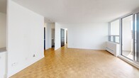 This well-appointed one-bedroom, one-bathroom unit on the 7th floor at 2397 Finch Avenue West offers a comfortable and functional layout across a generous single floor. The open-concept living and dining area is a standout feature, bathed in natural light through a wide expanse of floor-to-ceiling windows and a sliding glass door that leads to a private balcony overlooking the surrounding Toronto cityscape. Classic parquet flooring runs throughout the main living spaces and bedroom, adding warmth and character to the bright, white interior. The kitchen is thoughtfully updated with stainless steel appliances, including a range and over-the-range microwave, white cabinetry, dark countertops, and a clean subway tile backsplash — all set on light tile flooring. The spacious bedroom benefits from large windows that invite abundant natural light, complemented by a dedicated closet for storage. The bathroom has been renovated to a crisp, modern finish, featuring a white vanity with an undermount sink, subway-tiled tub surround, and stone-look floor tiles. The unit's clean, neutral palette and ample natural light create a bright and inviting atmosphere throughout.