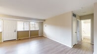 This single-floor residence at 11463 Lockwood Dr in Silver Spring, Maryland, offers a clean, updated interior with a straightforward layout. The living area is bright and open, featuring light wood-style flooring that extends throughout the main spaces. Large windows with horizontal blinds allow natural light to fill the room, while a front entry door with sidelights adds additional brightness. Neutral, warm-toned walls complement the light flooring throughout.

The kitchen is well-appointed with white shaker-style cabinetry, granite-patterned countertops, and a stainless steel single-basin sink. Black appliances include a gas range with overhead ventilation, a dishwasher, and a full-size refrigerator, providing a complete cooking setup. The kitchen connects conveniently to the main living space.

The bedroom features plush carpeting and offers generous storage with two side-by-side closets along one wall, providing ample wardrobe space. The neutral color palette keeps the room feeling clean and versatile.

The bathroom includes a full bathtub and shower combination enclosed by white square tile, maintaining a simple and functional aesthetic. Overall, the space presents a well-maintained, move-in ready interior with updated finishes throughout.