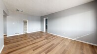 This 780 square foot single-story home in Albuquerque, NM offers a blend of comfort and functionality. The property features two bedrooms, including a primary bedroom of 170 square feet, and one bathroom. The interior showcases a modern aesthetic with a neutral color palette, predominantly light grey walls throughout.

The kitchen is a highlight, boasting white cabinetry with wooden accents, complemented by light-colored countertops and stainless steel appliances. The space is efficiently designed with a galley-style layout, featuring hardwood flooring that extends into the adjacent living area.

The living room is spacious and bright, with large windows allowing ample natural light. It features the same hardwood flooring as the kitchen, creating a seamless flow between the spaces. The bedrooms are carpeted for comfort, with the primary bedroom offering a built-in desk area and closet space.

The bathroom is modern and functional, with a single vanity and a shower/tub combination. Throughout the home, ceiling fans provide air circulation, enhancing comfort. The property's mixed flooring - hardwood in common areas and carpet in bedrooms - adds visual interest and practical functionality to the space.

Overall, this home presents a well-maintained, updated living space ideal for small families or first-time homeowners looking for a cozy, efficient property in Albuquerque.