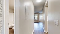 This single-floor residence offers a thoughtfully designed layout that balances functionality and comfort. The interior is characterized by a neutral color palette, textured ceilings, and a mix of wood-look flooring and plush carpeting that distinguish the living areas from the bedrooms.

The heart of the home is the updated kitchen, which features white shaker-style cabinetry, light quartz countertops, a white subway tile backsplash, and a full suite of stainless steel appliances including a refrigerator, range, dishwasher, and microwave. A window above the sink allows natural light to fill the space. A pass-through opening connects the kitchen to the adjacent living area, enhancing the open feel.

The living room is generously sized, with wood-look flooring, a ceiling fan, and a tiled fireplace that serves as a natural focal point. Windows along the perimeter allow for ample natural light throughout.

The bedrooms are finished with soft carpeting and feature windows that bring in outdoor views and light. A hallway connects the private areas of the home, passing by a bathroom equipped with a tub-shower combination, wood-look flooring, and clean white fixtures. The overall ambiance is bright, clean, and move-in ready.