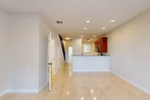 Located at 5504–5506 NW 31st Ave in Fort Lauderdale, Florida, this two-story property offers a well-organized layout across both levels. The main floor is characterized by large, polished ceramic tile flooring that runs throughout the open living and dining areas, contributing to a bright and clean aesthetic. Recessed lighting illuminates the space evenly, complementing the neutral white walls and clean baseboards.

The kitchen is a standout feature on the main level, equipped with rich cherry wood cabinetry, dark granite countertops, stainless steel appliances, and a peninsula that separates the kitchen from the living area—ideal for both casual dining and food preparation. A hallway leads past additional rooms and a staircase connecting to the upper floor.

A sliding glass door opens from the main living area directly to a private outdoor space framed by palm trees and greenery, allowing natural light to flow in. A full bathroom on the lower level features a glass-enclosed shower and tile flooring.

Upstairs, the bedrooms feature plush carpeting and dedicated closets with built-in shelving. A full bathroom on this level includes a tiled tub-shower combination, a vanity with storage, and tile flooring throughout, providing comfortable and functional accommodations.