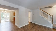 Located at 10573 Tralee Ct in Damascus, MD, this two-floor home offers a thoughtfully designed layout with a clean, move-in-ready aesthetic throughout. The main level features warm hardwood-style flooring that flows through the open living areas, complemented by neutral gray walls and crisp white trim. A staircase with a classic white balustrade and wood railing connects both floors. The kitchen is well-equipped with warm-toned wood cabinetry, granite-style countertops, a white subway tile backsplash, and black stainless steel appliances including a gas range, microwave, dishwasher, and refrigerator. A half bath on the main level includes a pedestal sink and framed mirror. The main level also provides direct exterior access through a paneled entry door. Upstairs, carpeted bedrooms offer a comfortable retreat, each filled with natural light from multiple windows overlooking lush greenery. The upper-level bathrooms are well-appointed, featuring a wood vanity with white countertop and a tiled shower with a decorative mosaic accent strip. Throughout the home, consistent finishes and neutral tones create a cohesive and inviting atmosphere suited for comfortable everyday living.