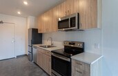 Located at 600 W Front St in the heart of Boise, Idaho, this single-floor unit offers a clean, modern aesthetic throughout. Polished concrete floors extend across every room, lending an industrial yet refined character to the space.

The kitchen is a standout feature, outfitted with light wood cabinetry, white quartz countertops, a classic subway tile backsplash, and stainless steel appliances including a range, over-the-range microwave, dishwasher, and refrigerator. The layout provides ample counter and storage space, making it both functional and visually appealing.

The open living area is bright and airy, benefiting from large windows that invite natural light and offer views of the surrounding Boise cityscape. A ceiling fan with a light fixture adds comfort and practicality to the space. The room connects seamlessly to the rest of the unit, creating a natural flow.

The bedroom is generously proportioned, featuring the same large windows and a ceiling fan overhead. A sliding-door closet with built-in wire shelving provides convenient storage.

The bathroom is well-appointed with a wood-toned vanity, white countertop, a full soaking tub and shower combination, and consistent polished concrete flooring. The overall design of the unit is cohesive, minimalist, and modern, making it a compelling space in downtown Boise.