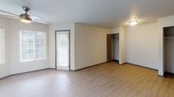 Located in Tacoma, WA, this single-floor unit offers a thoughtfully designed open-concept layout that seamlessly connects the kitchen and living areas. The light wood-style flooring runs throughout, creating a clean, cohesive aesthetic.

The kitchen is well-appointed with white shaker-style cabinetry, light granite-look countertops, stainless steel appliances including a refrigerator and electric range, and an overhead range hood. A breakfast bar provides a natural transition into the living space.

The living area is bright and airy, featuring multiple large windows with blinds that allow abundant natural light and views of surrounding greenery. The open floor plan provides a generous, flexible space for comfortable living.

The bedroom includes wood-look flooring, a closet with a hanging rod, a window for natural light, and a private exterior door — a practical and distinctive feature.

The bathroom is finished with a full tub and shower combination, accented by elegant marble-patterned surround panels that add a touch of refinement.

A dedicated laundry closet houses a stacked washer and dryer unit, offering the convenience of in-unit laundry. The overall design is modern and neutral, with warm tones and functional finishes throughout.